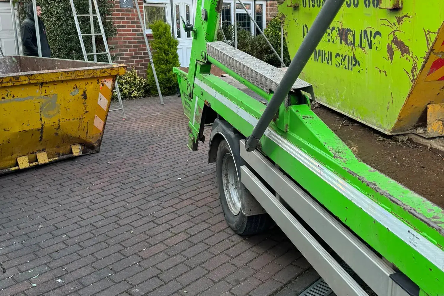 Skip delivery to a house under renovation with scaffolding