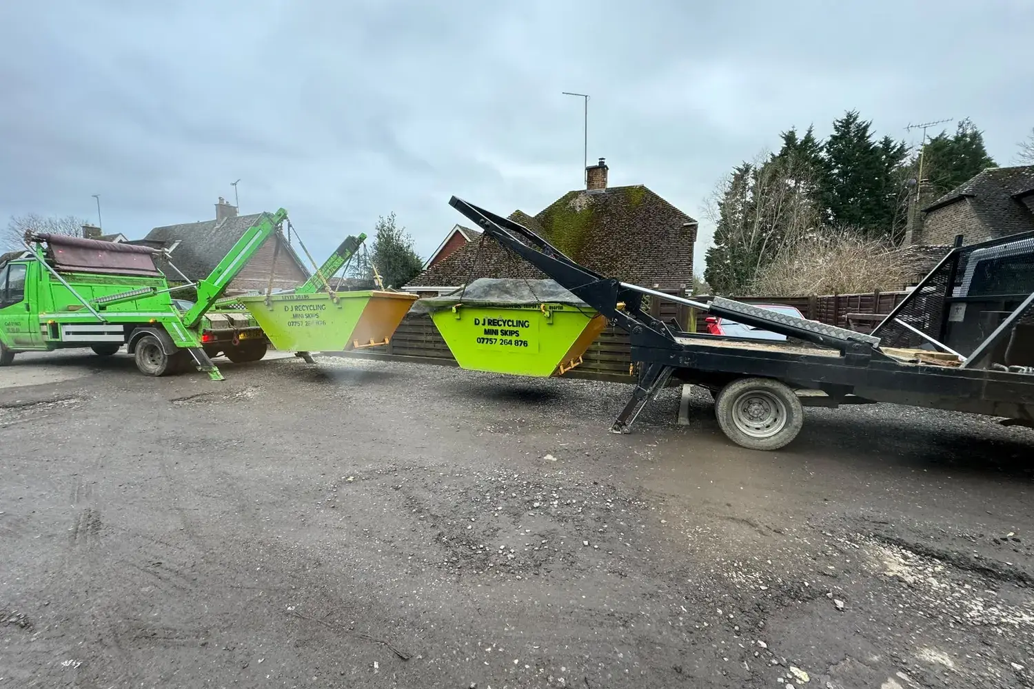 Two DJ Recycling skip lorries lifting mini skips